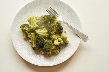 Healthy steamed broccoli on a white plate, ready to enjoy at mealtime.