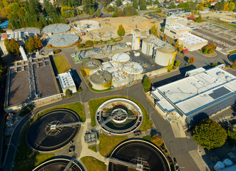 A view of a water treatment plant with several tanks and a large building