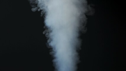 Close-up of white smoke clouds against a black background. Contrast of brightly lit smoke and dark room. Cinematographic light.