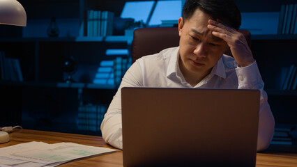 Asian stressed tired Korean man middle-aged exhausted overworked businessman laptop working problem...