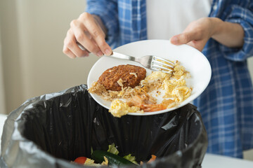 Compost from leftover food, refuse asian young housekeeper woman, girl hand using fork scraping waste from dish, throwing away putting into garbage, trash or bin..Environmentally responsible, ecology.