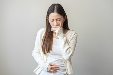 Unhappy pregnant asian young woman, pain girl suffering from nausea, having vomit feeling sick covering mouth, touching belly having problem throwing up from food poisoning, lady with morning sickness