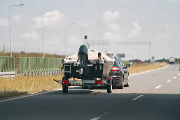 Car transporting boat on a highway
