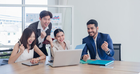 Obraz premium Business team woman and man asian group meeting sitting on desk looking talk think creative idea computer on table ready happy working new project job online product sale marketing in office company.