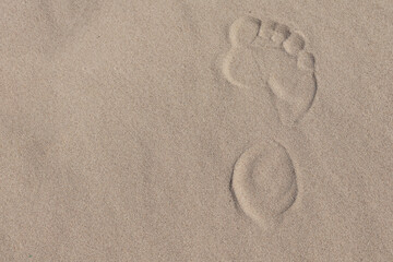 A footprint of a human's bare foot in the sand