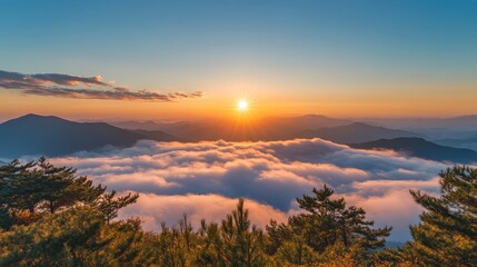 Obraz premium A stunning sunrise over a sea of clouds with a mountain range in the background, creating a picturesque and peaceful scene.