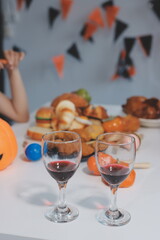 friendship, holiday and people concept - group of happy smiling friends in halloween costumes of vampire, devil, witch and cheetah at home party