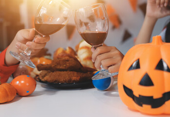 friendship, holiday and people concept - group of happy smiling friends in halloween costumes of vampire, devil, witch and cheetah at home party