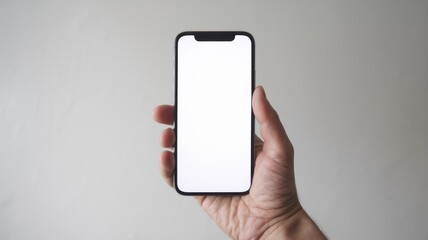 Hand holding smartphone with blank screen, minimalist background.