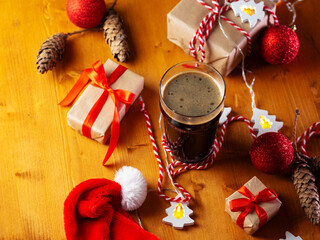 Top view Christmas dark ale , gift boxes with red ribbons, festive balls and garlands