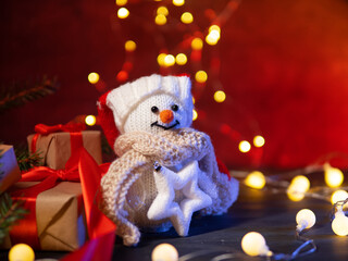snowman and Christmas gift boxes on a red background. Copy space