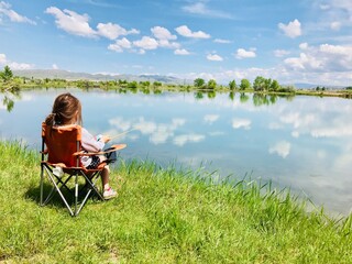 child fishing, mountain lake,  blue sky fishing, camping chair, fishing.