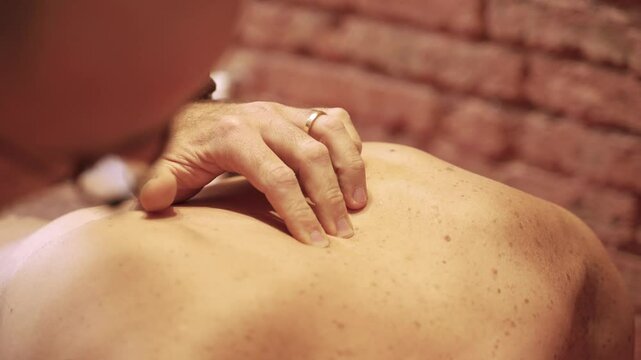 Osteopath performing gentle back manipulation, manual therapy technique on patient in modern clinic setting