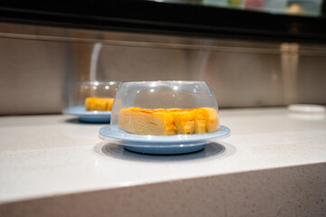 various types of sushi on conveyor belt in a Japanese restaurant. Shushi Go Round is a famous form...