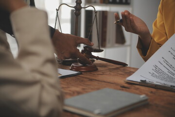 Judge gavel with Justice lawyers having team meeting at law firm background. Concepts of Law and Legal services.