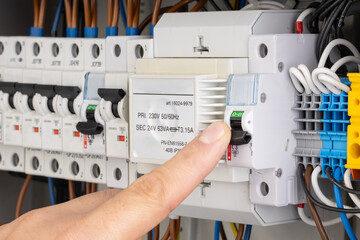 Finger Switching Off Circuit Breaker in Electrical Panel