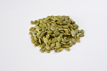 a heap of green pumpkin seeds with a white background