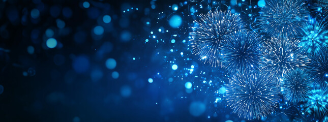 Blue fireworks against a dark blue sky background with copy space, a banner design. New year celebration concept.