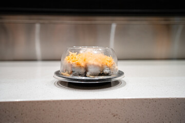 various types of sushi on conveyor belt in a Japanese restaurant. Shushi Go Round is a famous form...