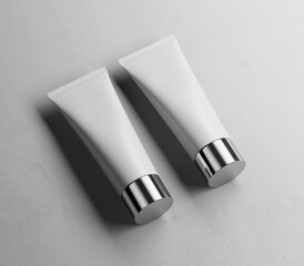 Two cosmetic metal cap tubes mockup on the concrete floor