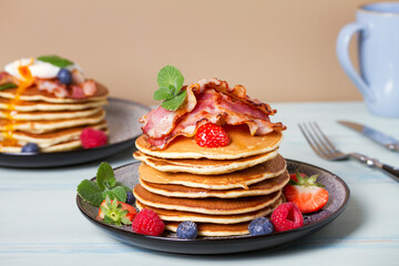 Fluffy pancakes with bacon, poached eggs and berries