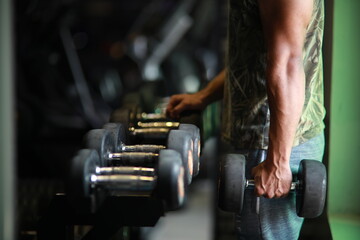 Fitness and healthy background concept. Dumbbells with blurred gym or sport club background at sunset.