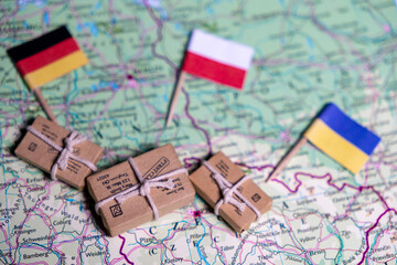 The flags of Germany, Poland and Ukraine lie on a world map next to delivered parcels. Economy, aid, trade