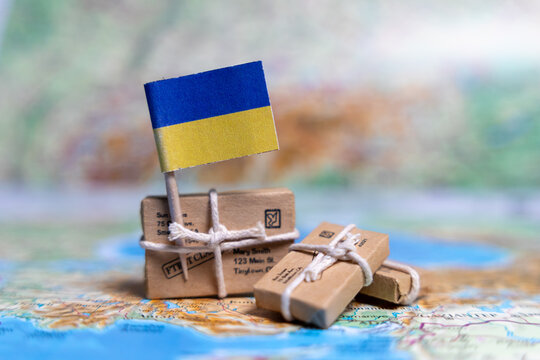 Flag of Ukraine near the parcels on the world map. World trade. Exports and imports of goods. Economy of the country. - Powered by Adobe