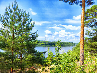 Scenic view of a tranquil river surrounded by lush green trees under a bright blue sky in summer
