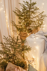 Designer Christmas tree decoration with light decorations. The concept of celebrating New Year and Christmas. Gifts in craft packaging under the Christmas tree