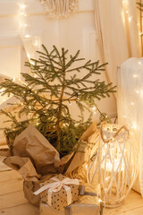 Designer Christmas tree decoration with light decorations. The concept of celebrating New Year and Christmas. Gifts in craft packaging under the Christmas tree