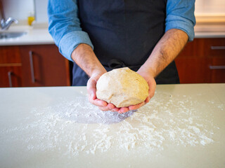 youg man showing a fresh wheat flour dough