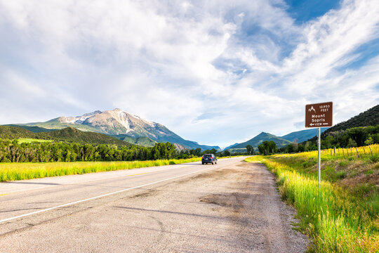 Mount Sopris mountain peak road highway sign in Carbondale, Colorado with grass farm ranch field open pasture field