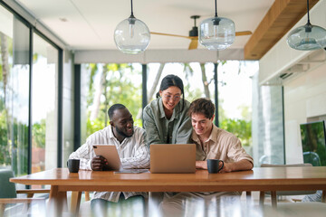 Diverse Team of Smiling Business Professionals Working on Laptop