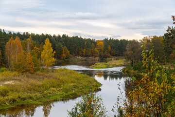 Autumn river landscape. Forest riverside in autumnal landscape.