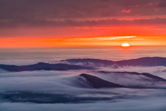 Wintergreen Resort, Virginia sunrise of sun behind clouds horizon and mist fog above Blue Ridge mountains in autumn fall