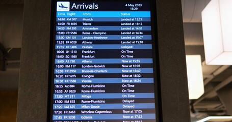 Digital flight information display with schedule for passengers on concrete wall. Airport departures info performed for customers comfort in terminal hall