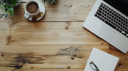 A minimalist desk with just a coffee cup, open notebook, and laptop, placed on a light wooden surface with plenty of negative space