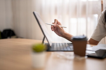 Businesswoman working from home using digital tablet and stylus