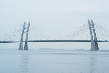 Obraz premium distant bridge over foggy bay on rainy day