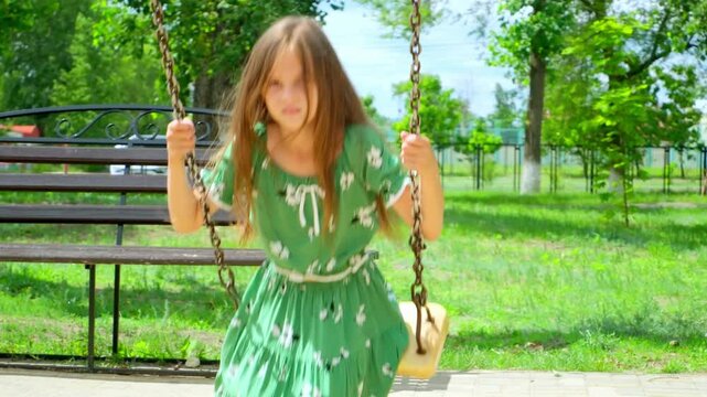 Happy little girl laughing swinging on swing enjoy childhood summer outdoor playground with positive emotion. Child flying playing cheerful activity excitement enjoy freedom