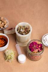 Homeopathy. Homeopathic medicines, small pills, herbs in a glass jar on a kraft background. Alternative medicine.