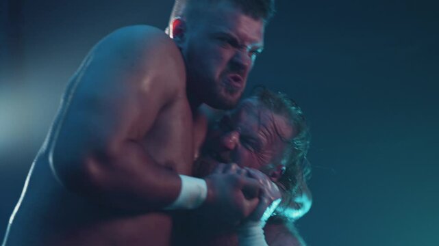 Pro wrestler puts his opponent in a headlock during wrestling match