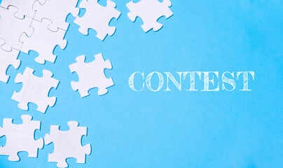 A blue background with white puzzle pieces and the word Contest written in white