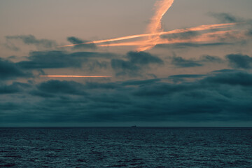 The sky is cloudy, casting a grey hue over the vast expanse of water