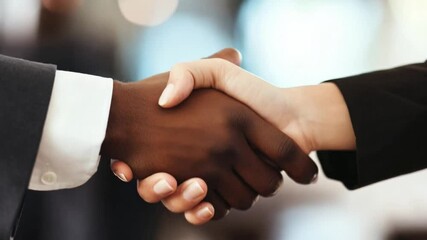 Two individuals are shaking hands to signify agreement and collaboration in a business environment