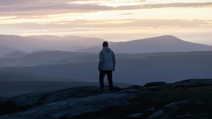 Fototapeta premium Contemplative Figure Overlooking Dusk Landscap