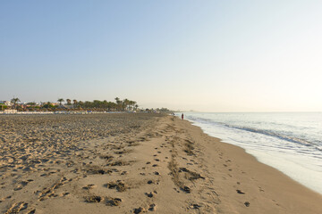 Seashore of Los Alamos beach in Torremolinos, Malaga. View of the Mediterranean Sea at sunrise, with the horizon line and clear sky. In Andalusia, Spain