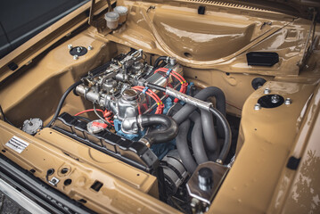 Open bonnet of a classic car displaying fully restored engine compartment.
