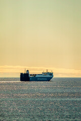 A large ship is currently floating peacefully on a vast body of water